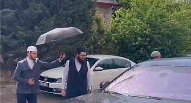 Mürteci Menzil Örgütünün Elebaşının Oğlu Kendini Bir Şey Zannetti: Lüks Aracından İnerken Müridine Şemsiye Tutturdu
